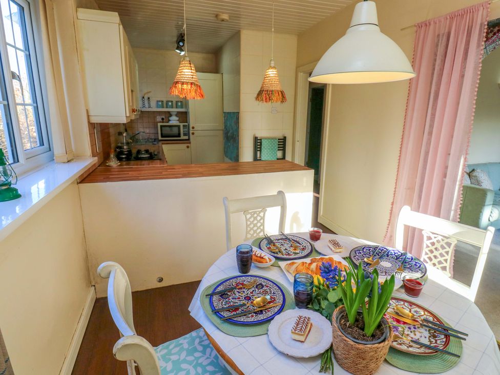 A kitchen with dining area and table set at Hira's Cottage