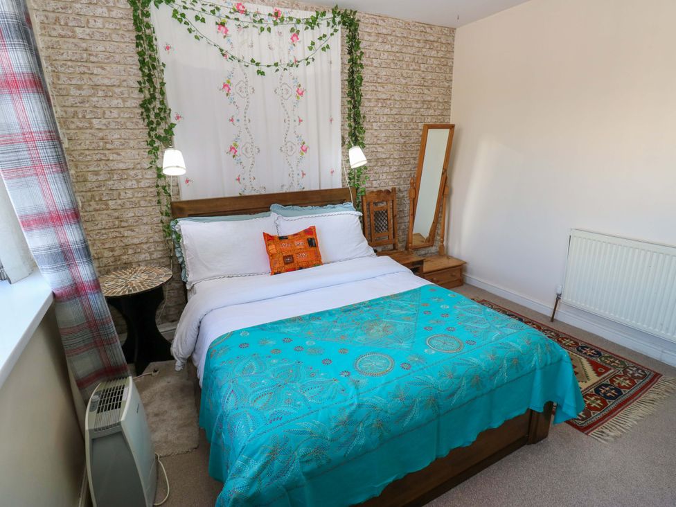 A bedroom with a bed and decorative bedding at Hira's Cottage