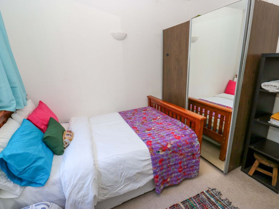 A bedroom with a bed and wardrobe at Hira's Cottage