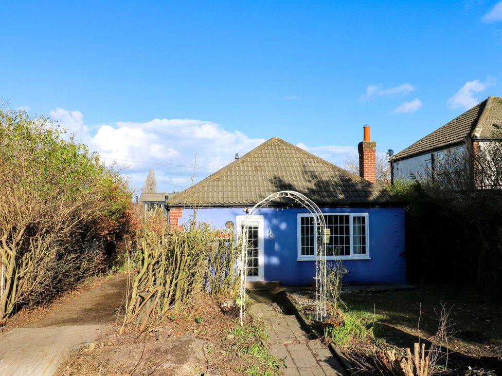 A house with a chimney and pathway surrounded by hedges at Hira's Cottage
