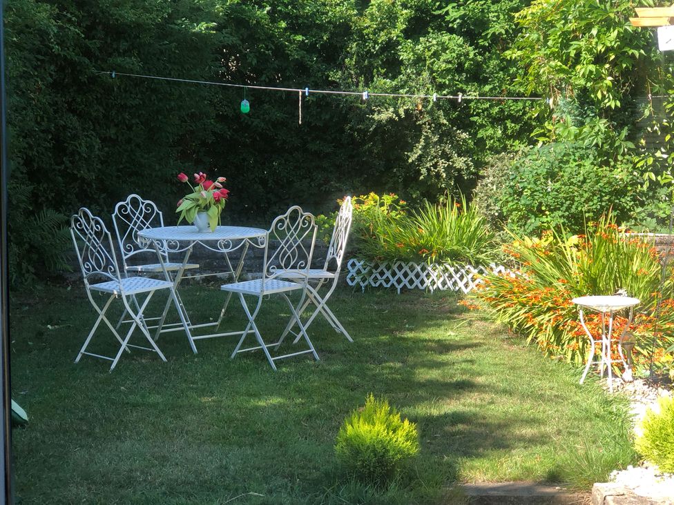 A garden with a table and chairs at Hira's Cottage in Bradford