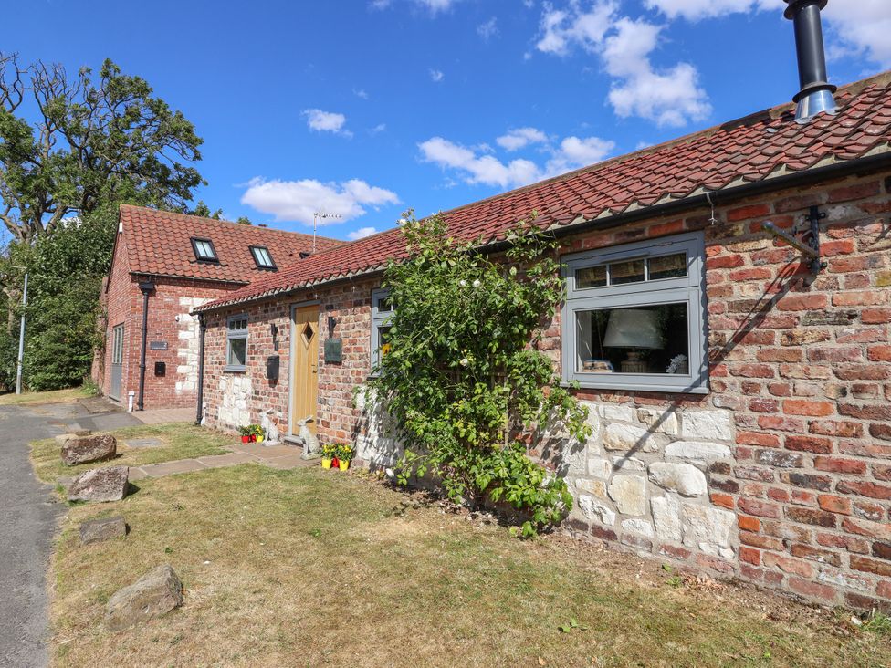An exterior view of a barn with a pathway and garden at 1 Church Barns Pocklington