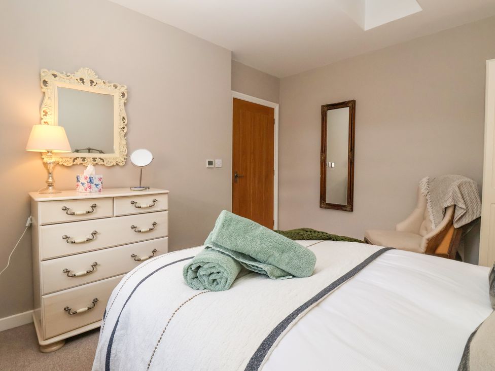 A bedroom with a bed, dresser and chair at 1 Church Barns in Pocklington