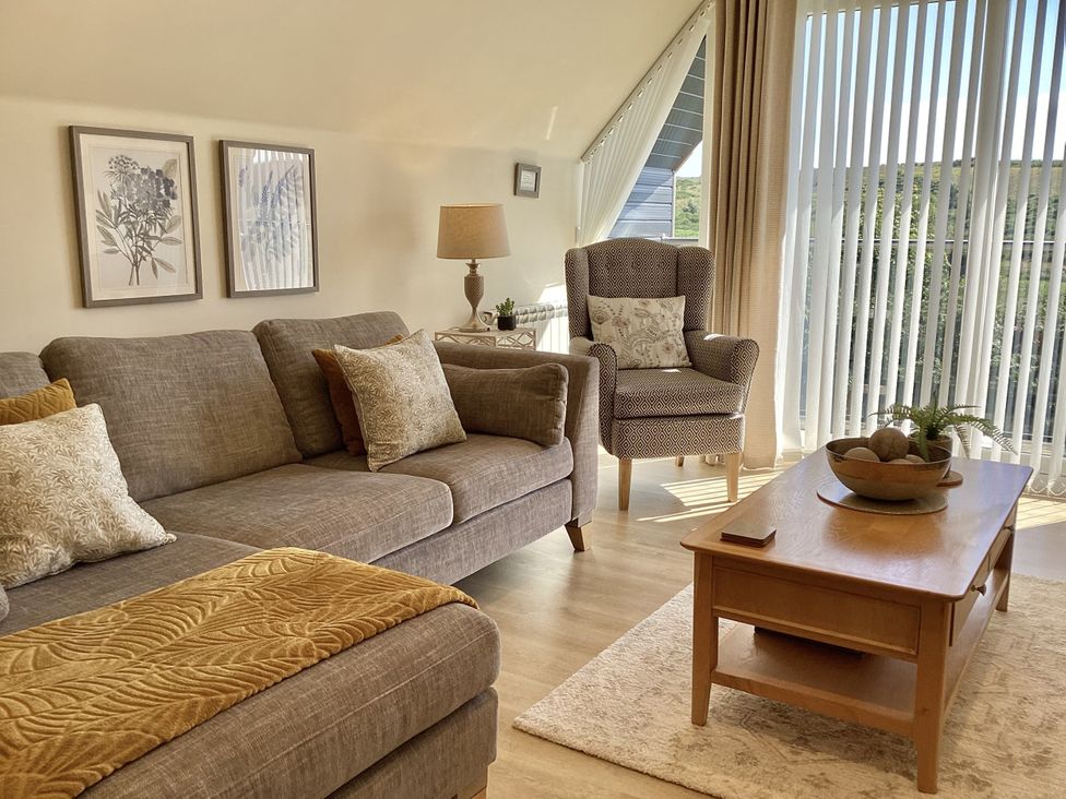 A living room with a sofa and armchair at Larchwood Lodge in Ellon