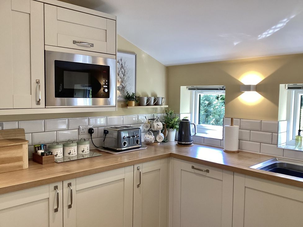 A kitchen with a microwave, kettle, and toaster at Larchwood Lodge in Ellon