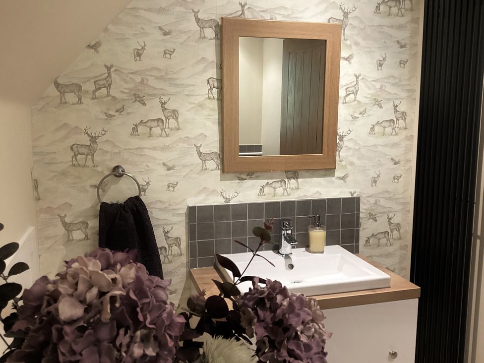 A bathroom with a sink and mirror at Larchwood Lodge in Ellon