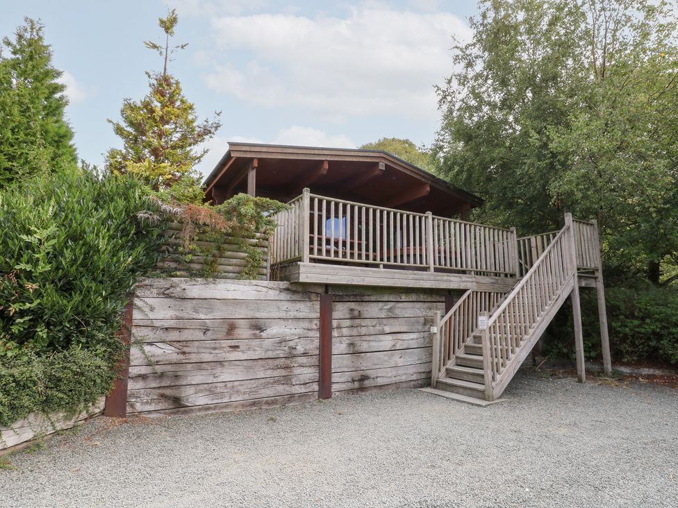 A wooden cabin with a deck and stairs at Sunny View in Rhayader