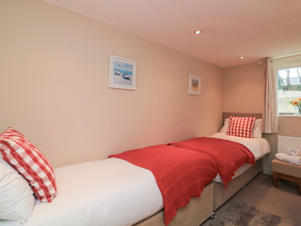 A bedroom with two beds and paintings at Lanapoule in Salcombe
