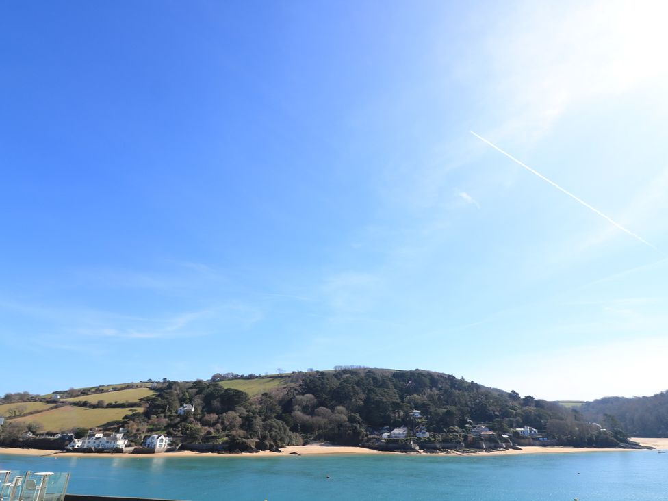 A waterfront view with hills and houses at Lanapoule Salcombe