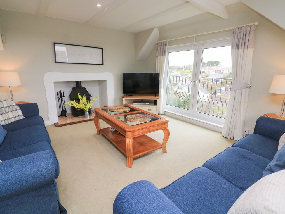 A living room with a television and fireplace at Lanapoule in Salcombe