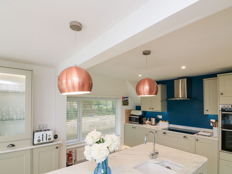A kitchen with cabinets and appliances at Lanapoule Salcombe