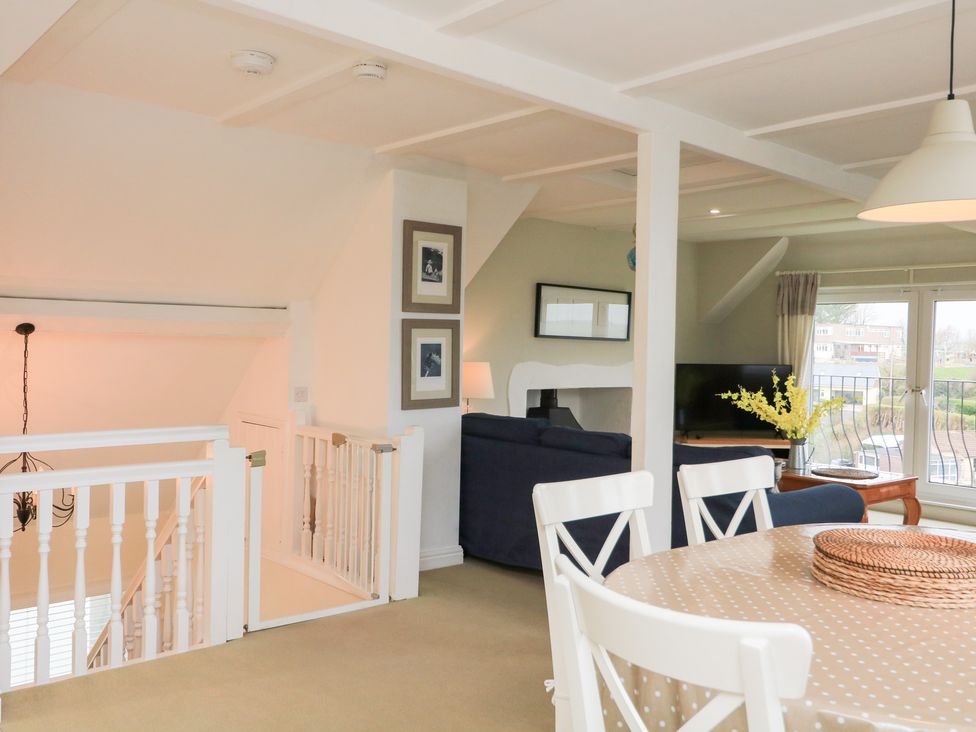 A dining room with a table and chairs along with a view at Lanapoule Salcombe