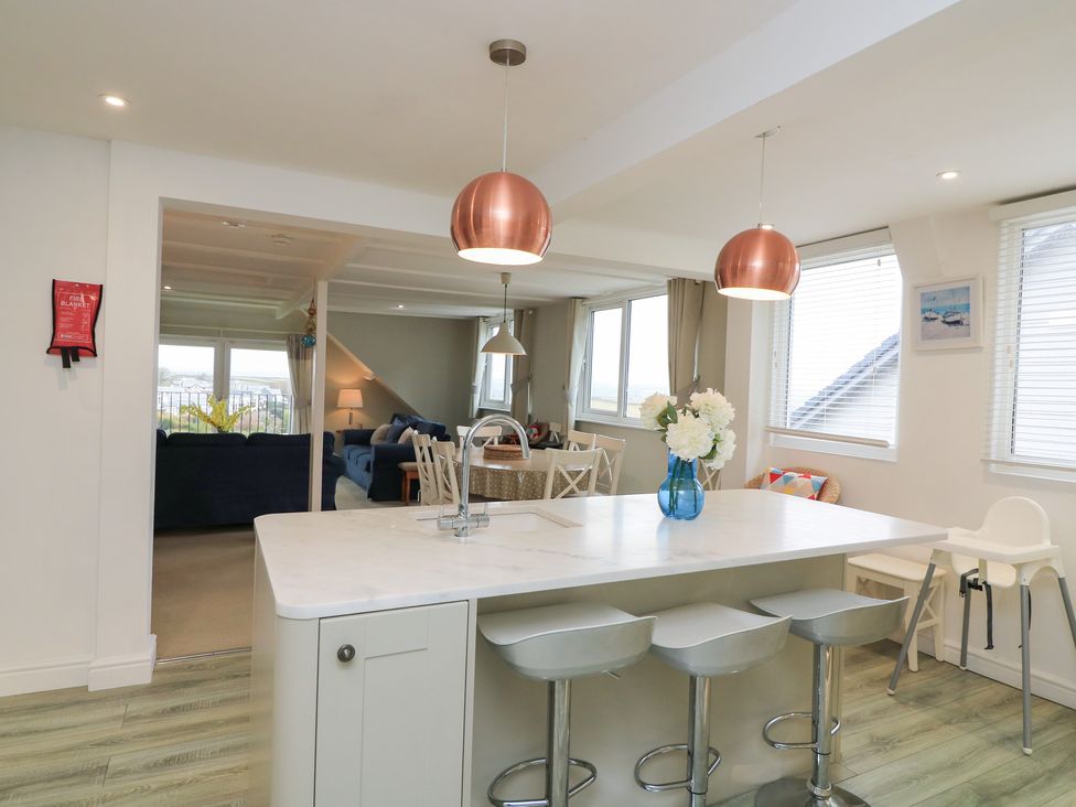 A kitchen with an island and bar stools at Lanapoule, Salcombe