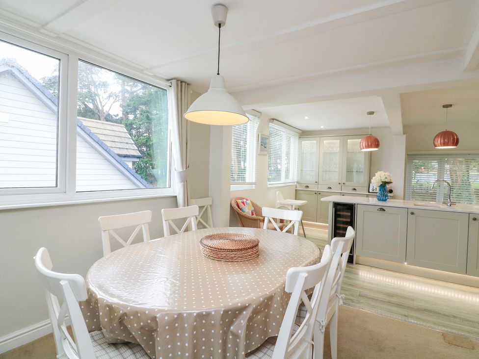 A dining room with a round table and chairs at Lanapoule in Salcombe