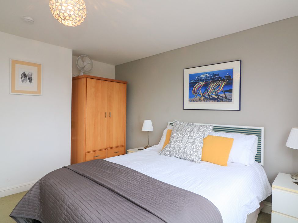 A bedroom featuring a bed with pillows and a wardrobe at Lanapoule in Salcombe