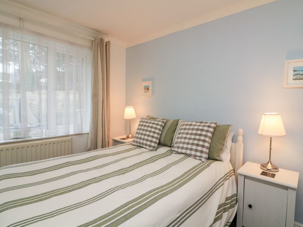 A bedroom with a bed and lamps at Lanapoule Salcombe