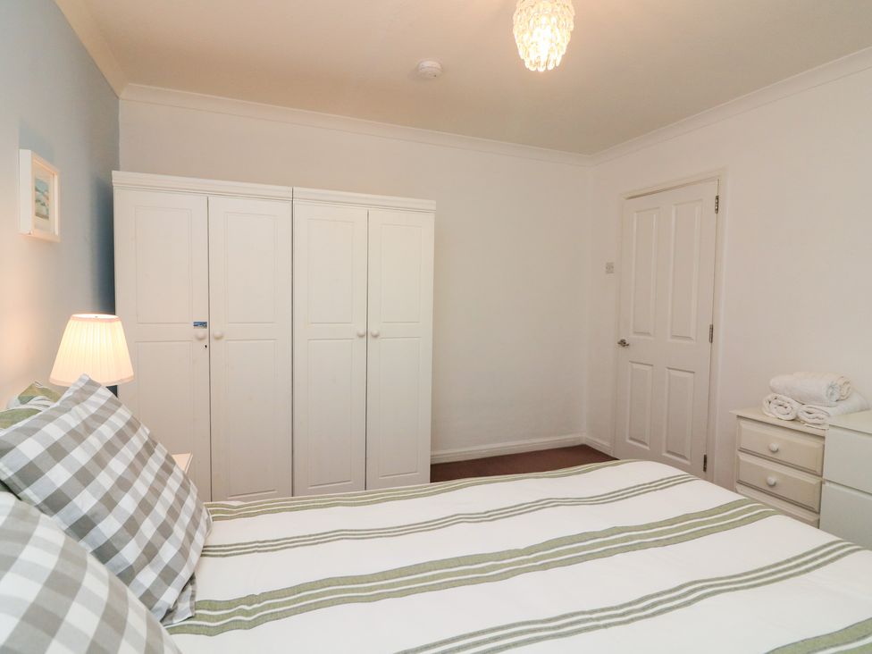 A bedroom with a bed and wardrobe at Lanapoule in Salcombe
