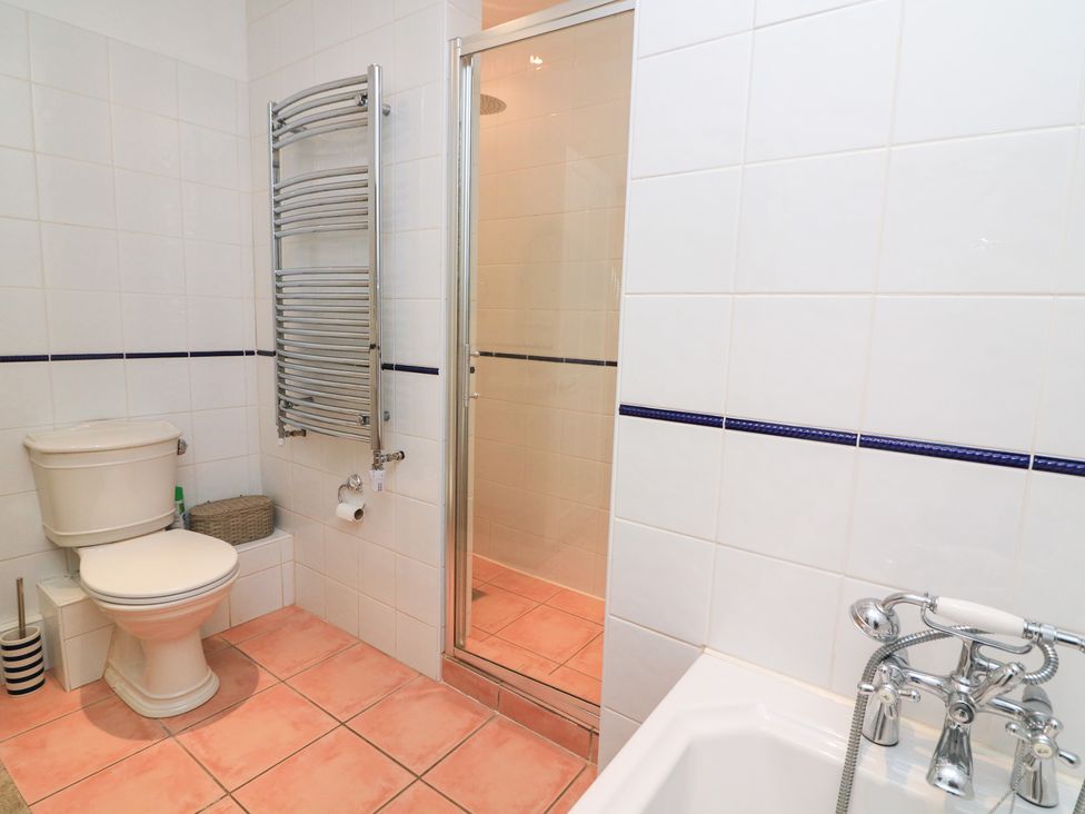 A bathroom with a shower, bathtub, toilet, and towel radiator at Lanapoule Salcombe