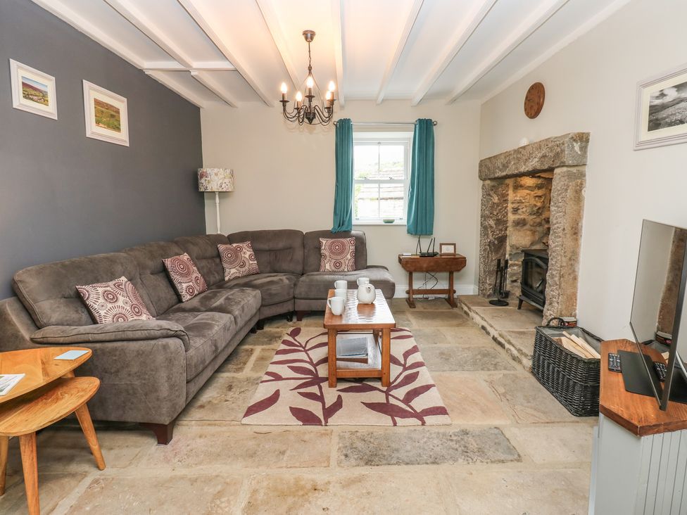 A living room with a sofa and a fireplace at White Lea in Reeth