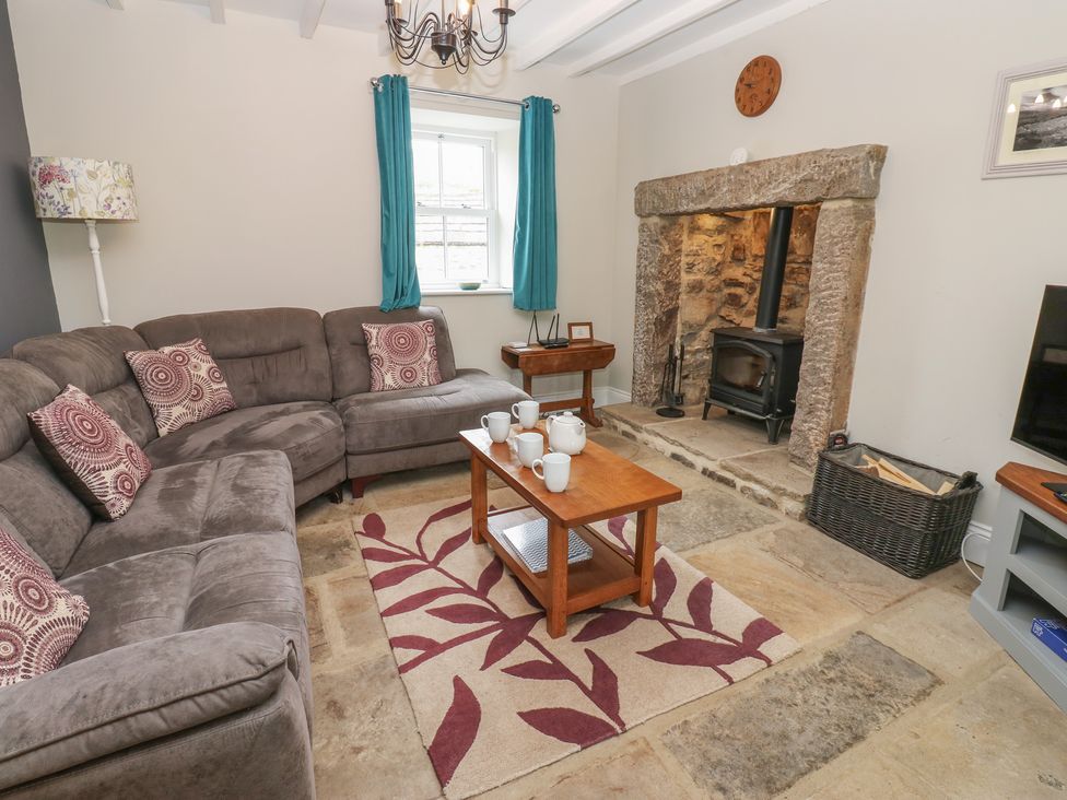 A living room with a sofa and fireplace at White Lea in Reeth