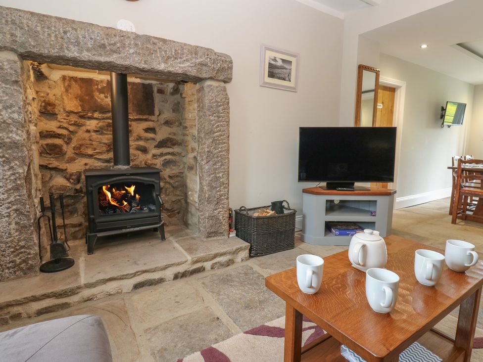 A living room with a fireplace and television at White Lea in Reeth