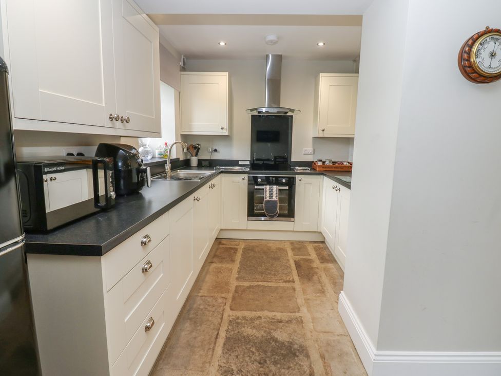 A kitchen featuring a stove, sink, and microwave at White Lea in Reeth