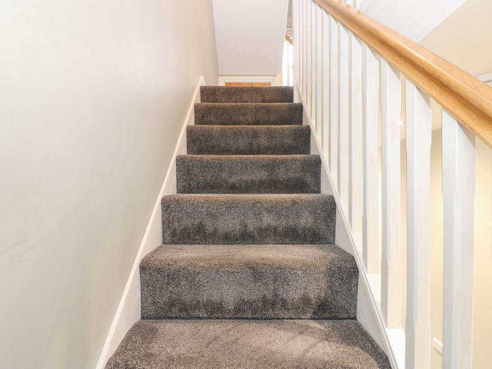 A staircase with a carpet and handrail at White Lea in Reeth