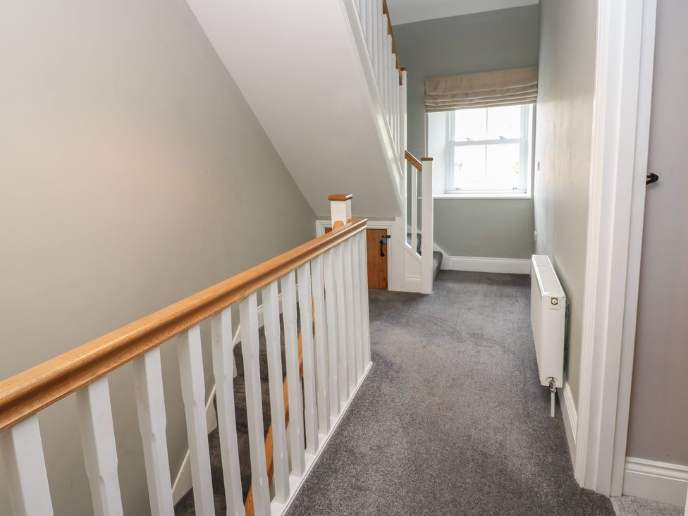 A hallway with a staircase and window at White Lea in Reeth
