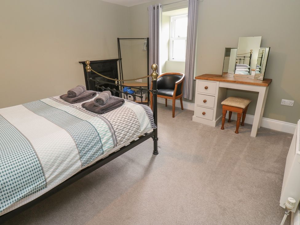 A bedroom with a bed and desk at White Lea in Reeth