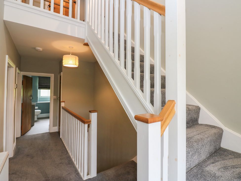 A hallway with a staircase and light fixture at White Lea in Reeth