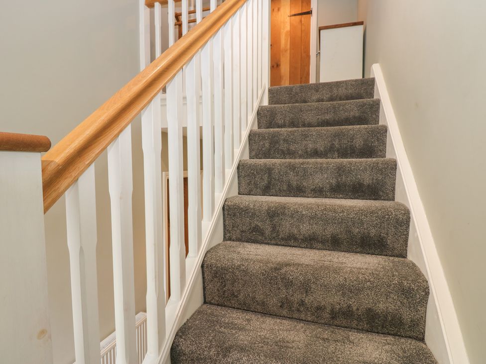 A staircase with carpet and handrail at White Lea in Reeth