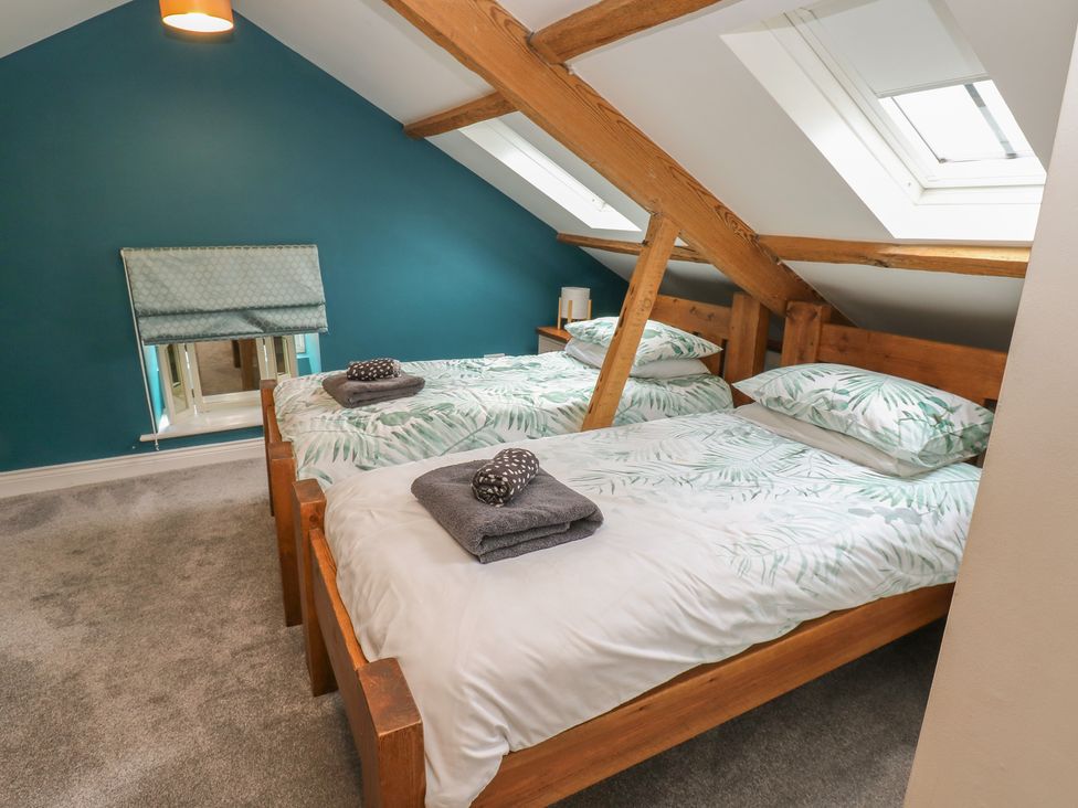 A bedroom with two beds and a window at White Lea in Reeth
