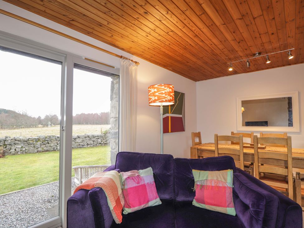 A living room with a sofa and dining table at Inshcraig in Kincraig near Aviemore