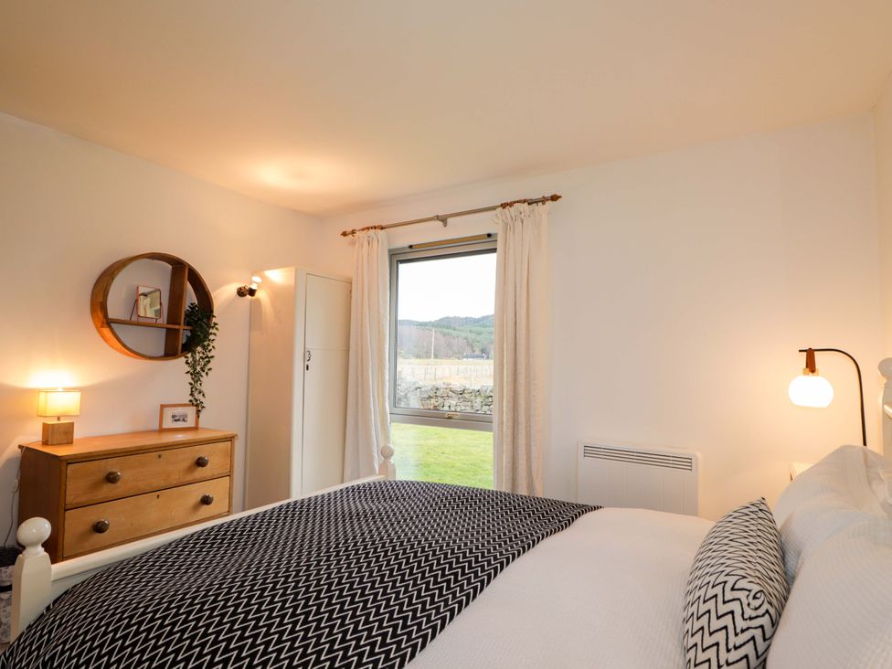 A bedroom with a bed and dresser at Inshcraig in Kincraig near Aviemore