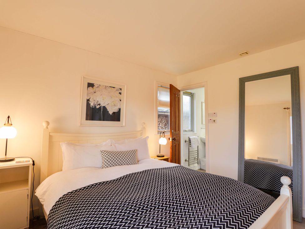 A bedroom with a bed and mirror at Inshcraig Kincraig near Aviemore