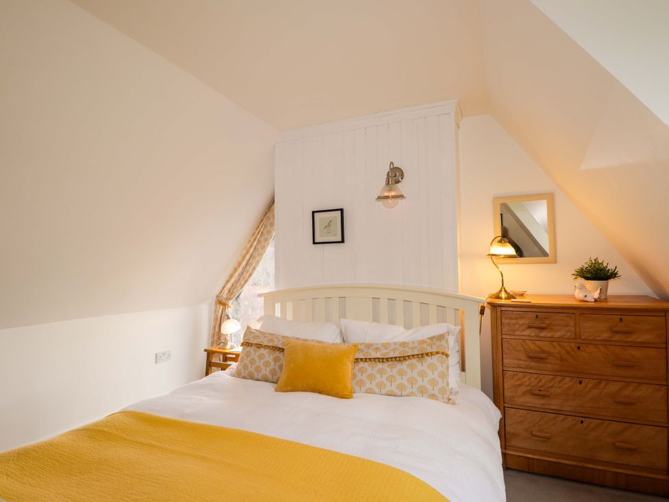 A bedroom with a bed and chest of drawers at Inshcraig in Kincraig near Aviemore