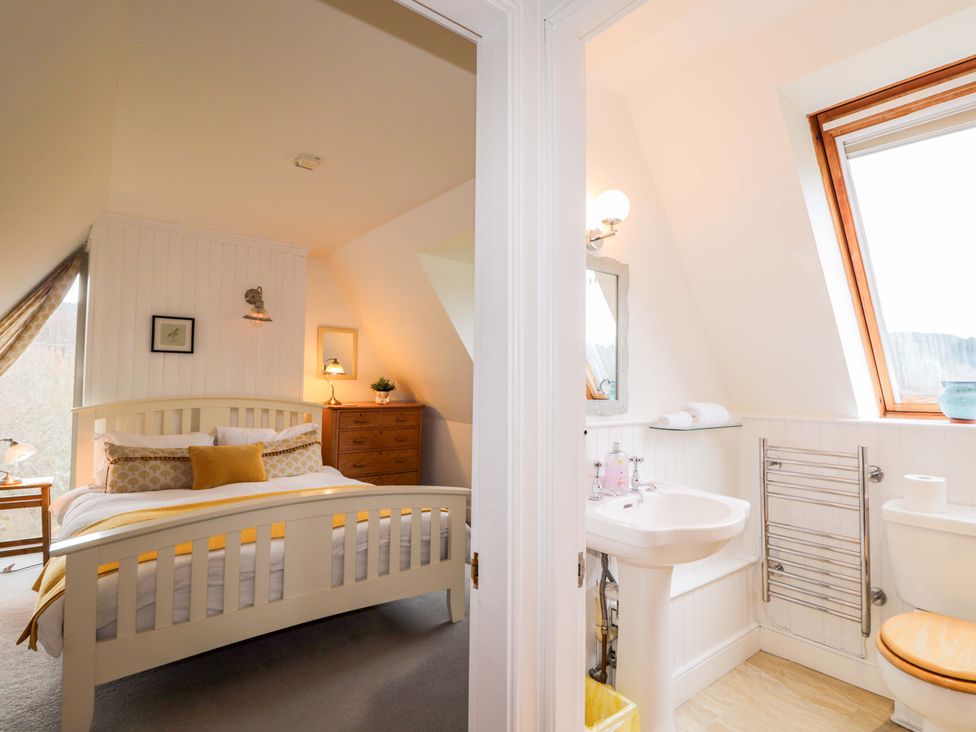 A bedroom with a bed and attached bathroom at Inshcraig in Kincraig near Aviemore