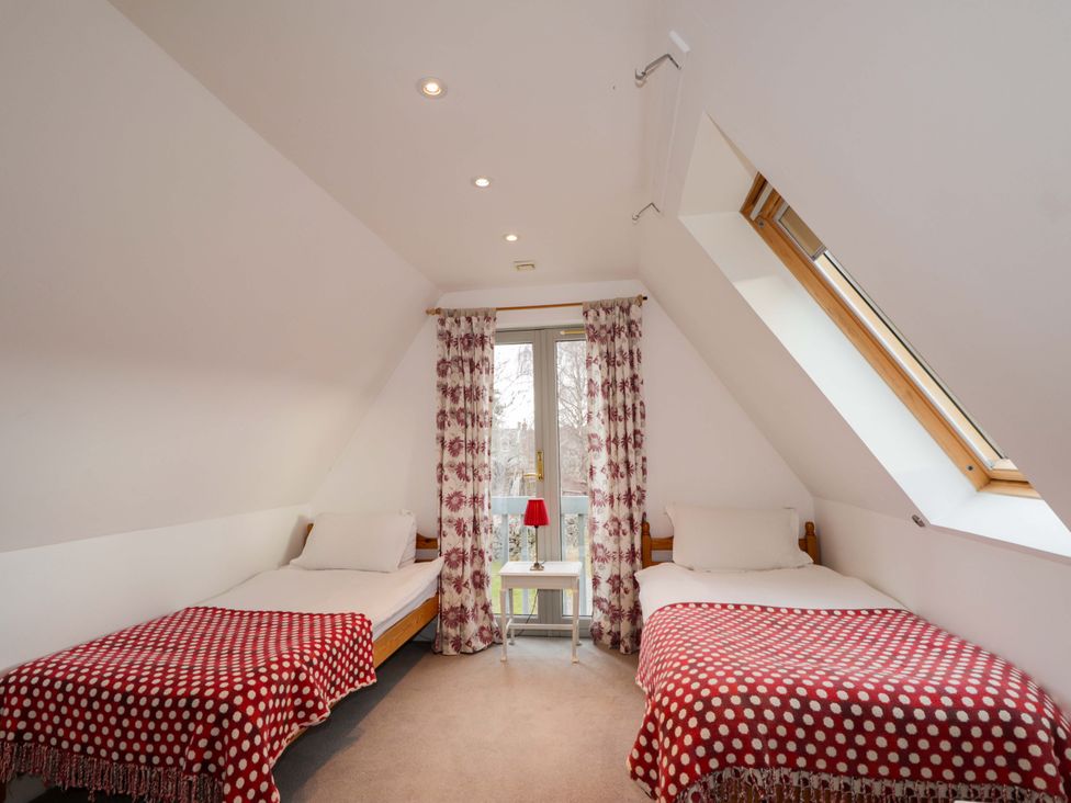 A bedroom with two beds and a bedside table at Inshcraig in Kincraig near Aviemore