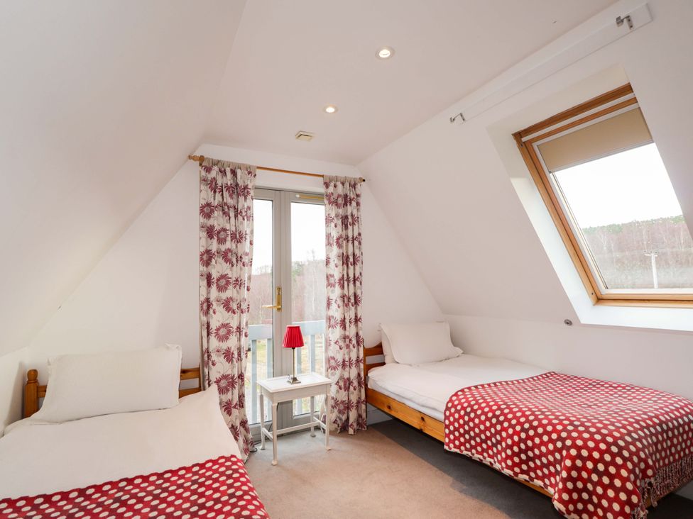 A bedroom with two beds and a table at Inshcraig Kincraig near Aviemore