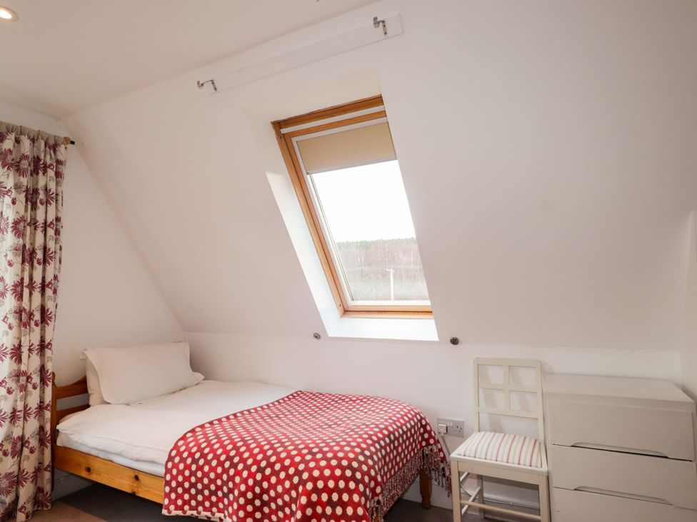 A bedroom with a bed and window at Inshcraig in Kincraig near Aviemore