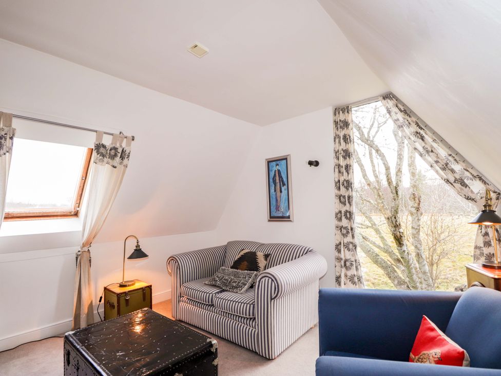 A living room with striped sofa and window at Inshcraig in Kincraig near Aviemore