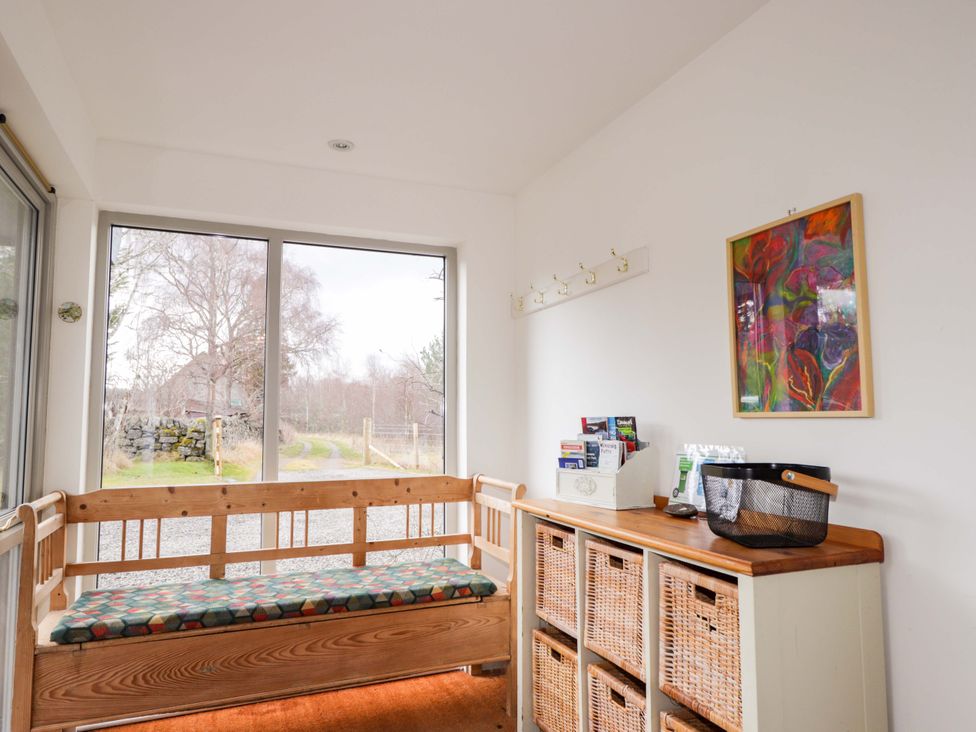 A hallway with a bench and storage baskets at Inshcraig in Kincraig near Aviemore