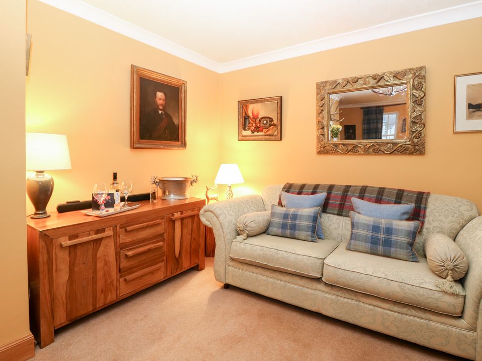 A living room with a sofa and sideboard at 1 The Cross in Dunkeld