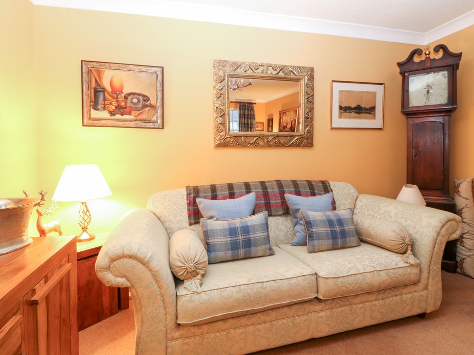 A living room with a sofa and lamp at 1 The Cross in Dunkeld