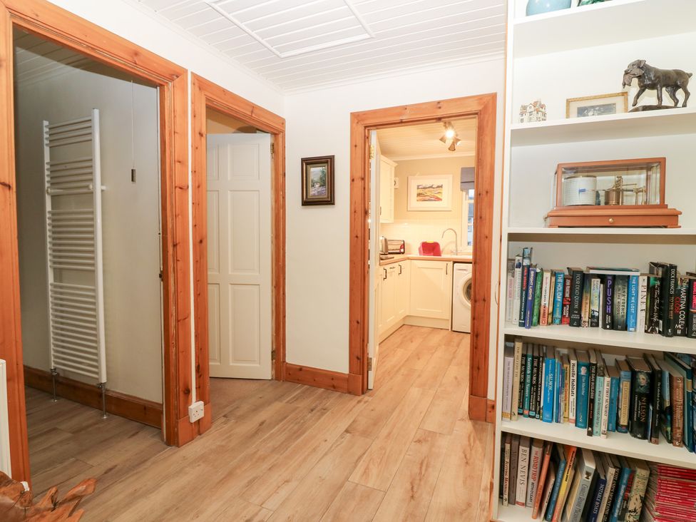 A hallway with a shelf and two doors at 1 The Cross in Dunkeld