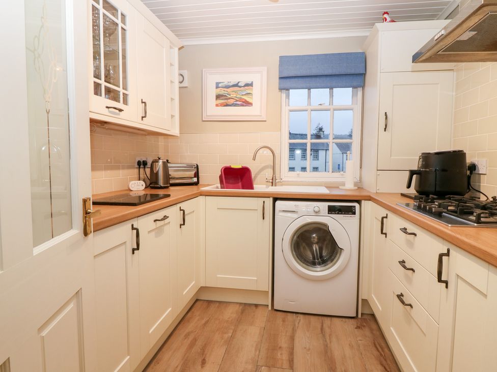 A kitchen with a washing machine and sink at 1 The Cross Dunkeld