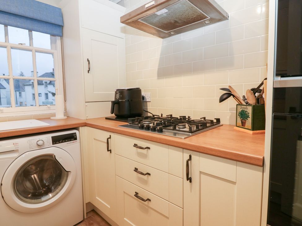 A kitchen with a washing machine and stove at 1 The Cross in Dunkeld