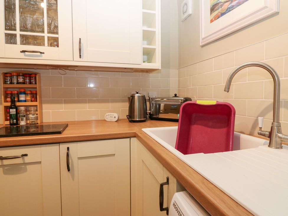 A kitchen with a sink and storage shelves at 1 The Cross, Dunkeld