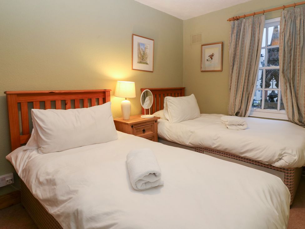 A bedroom with two beds and a lamp at 1 The Cross Dunkeld