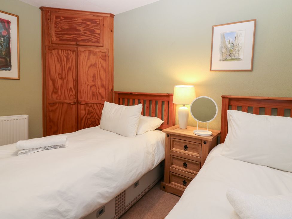 A bedroom with two single beds and a bedside table at 1 The Cross Dunkeld
